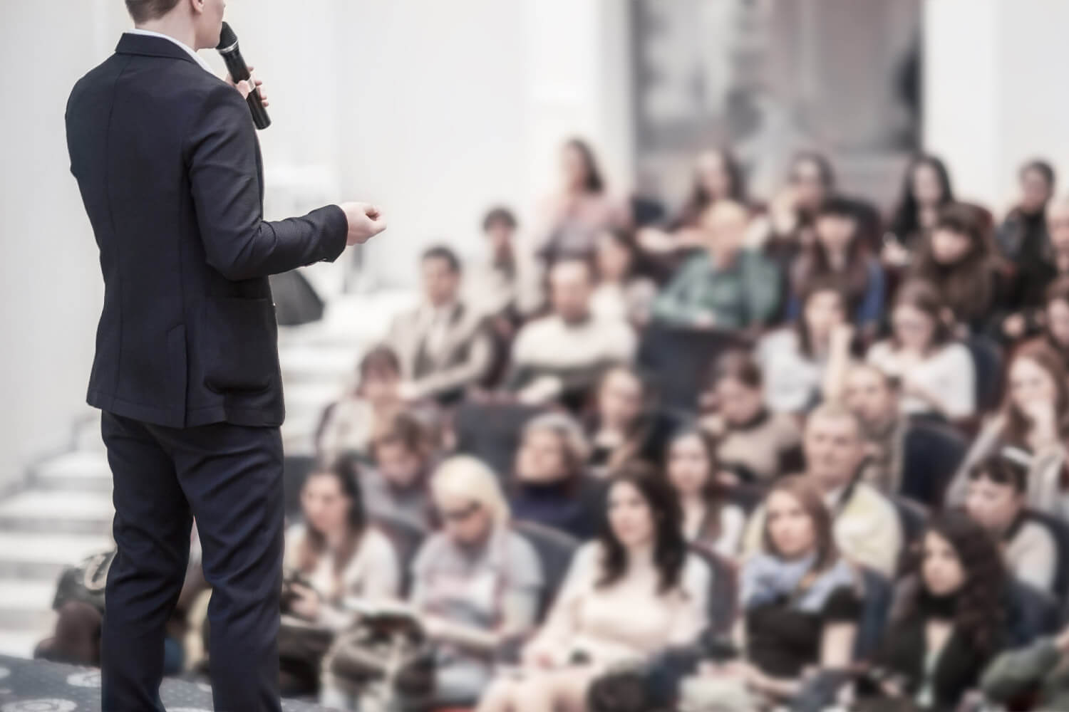 Tips for Picking the Best Title for Your Event - man in suit leading a seminar in an auditorium